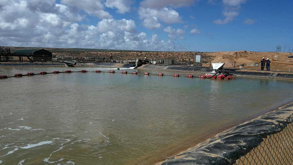 The SlurrySucker dredging unit comprises a floating barge with an electric hoist operated from the side of the dam.